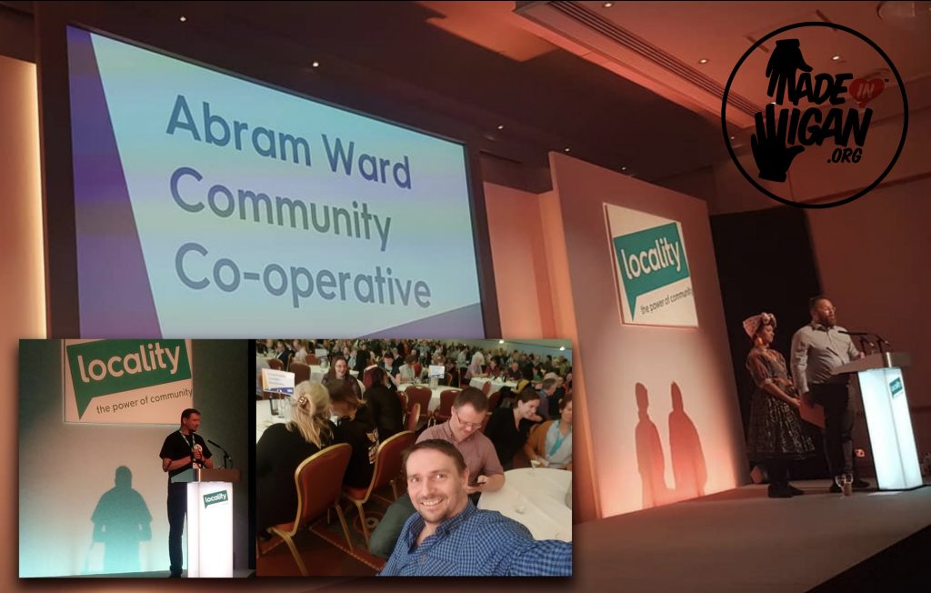 A conference stage with a screen reading 'Abram Ward Community Co-operative', alongside Locality branding and photos from the event