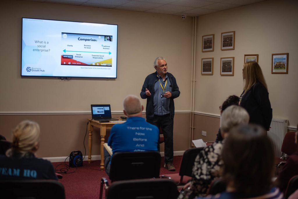 A facilitator presenting a slide asking 'What is a social enterprise?' to delegates at the Proper Good launch
