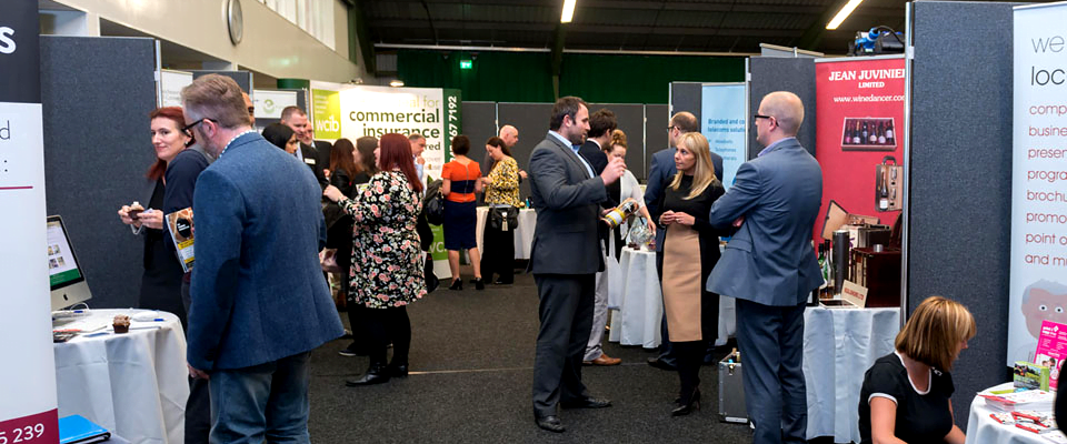 Exhibitors and visitors networking between stands at a Wigan business expo
