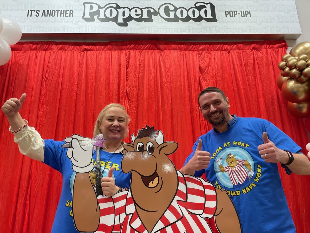 Two guests giving a thumbs up beside the cartoon cut-out at the Proper Good pop-up