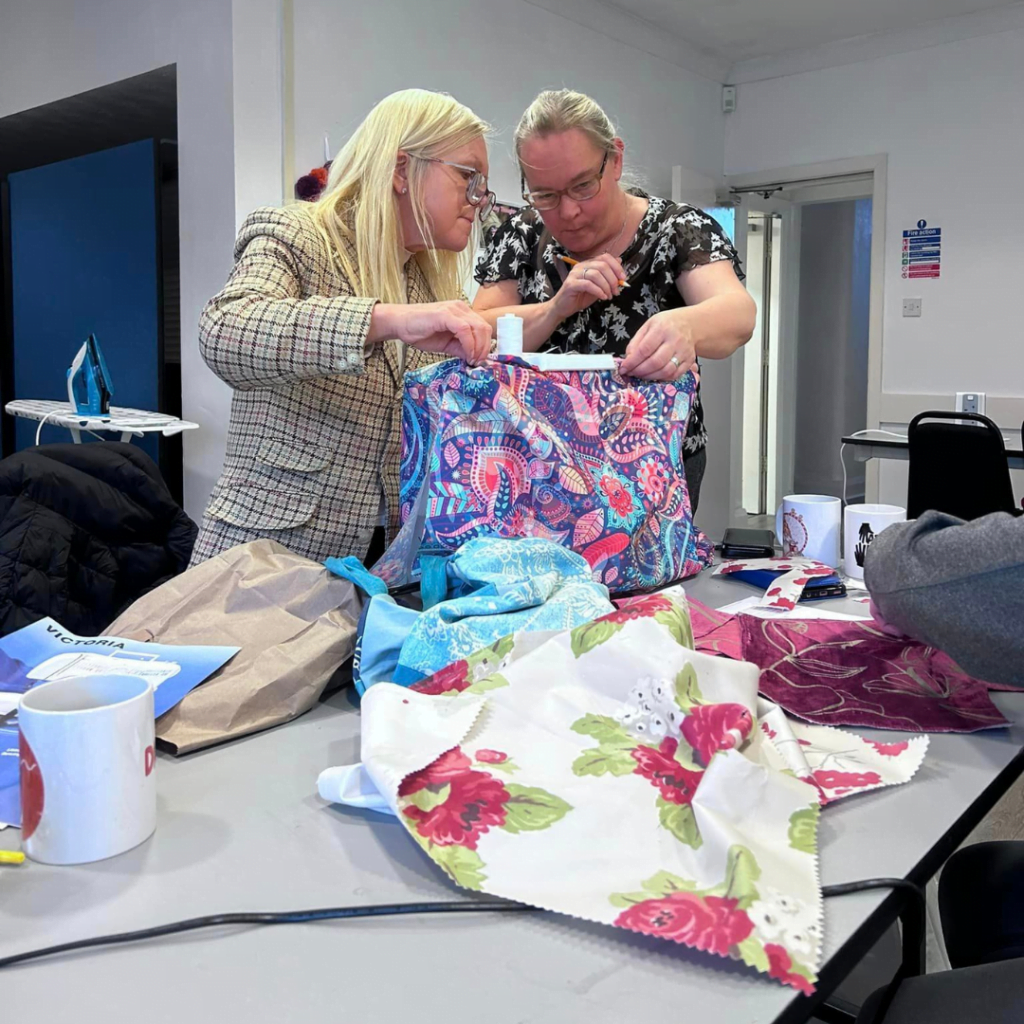 Two participants working with patterned fabric at a craft and sewing workshop