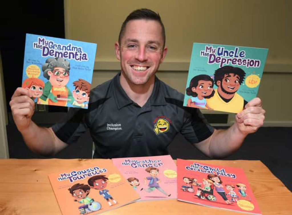 An Inclusion Champion holding up two of the children's books, 'My Grandma Has Dementia' and 'My Uncle Has Depression', with more titles on the table