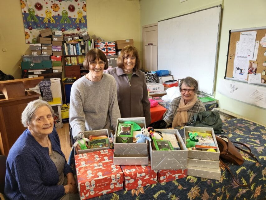 Volunteers with shoeboxes filled with donated gifts and toys ready for the Christmas appeal